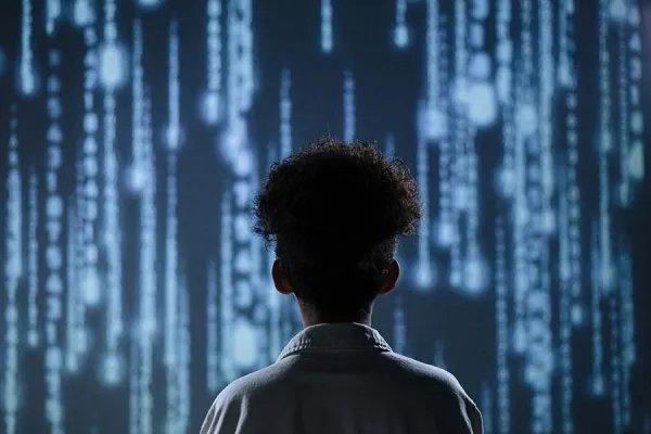 Photo from behind of a young person watching a projection of cascading numbers