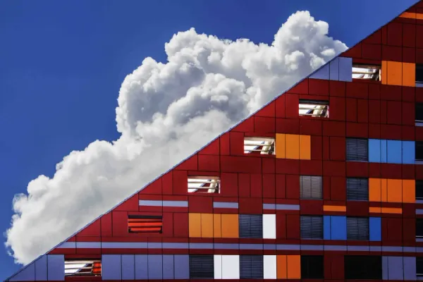 Triangular red building with white cloud behind it