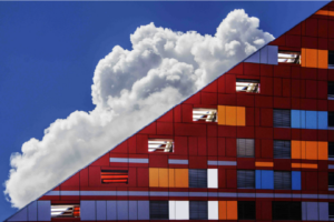 Triangular red building with white cloud behind it