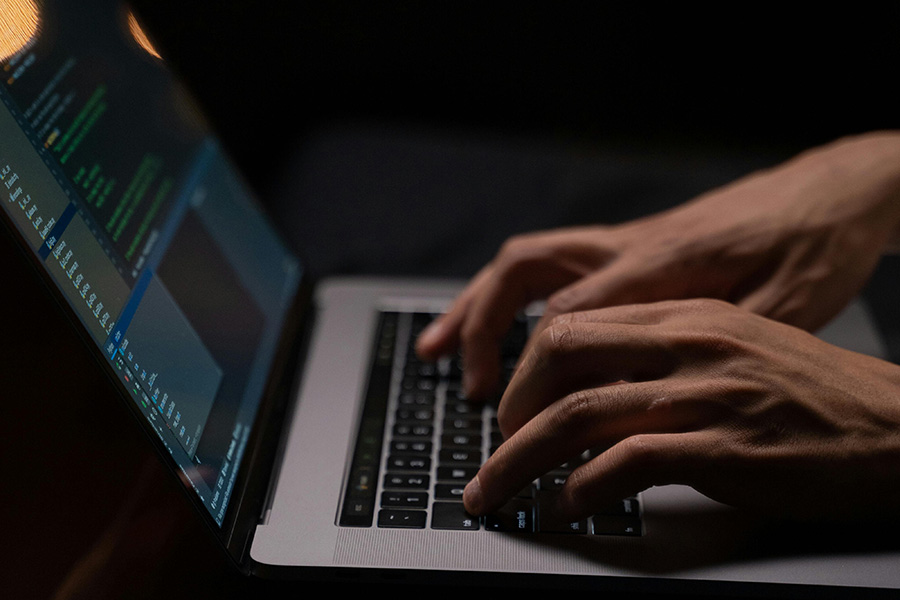 Hands typing on an open laptop