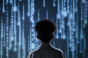 Photo from behind of a young person watching a projection of cascading numbers